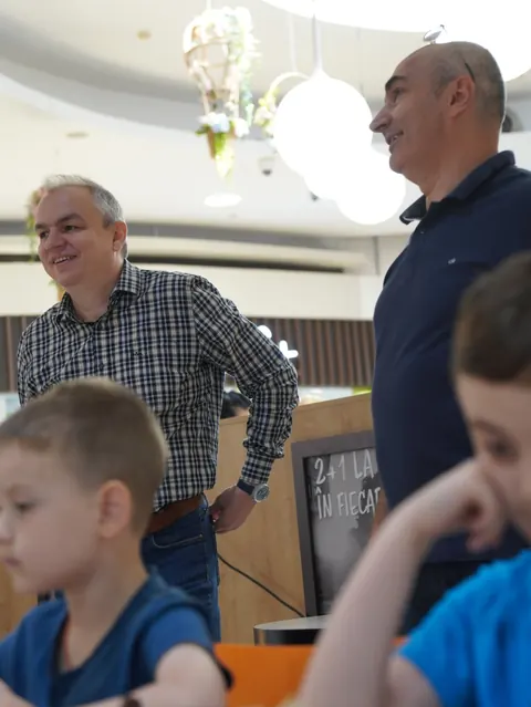 Organizatori alături de copii la un turneu de șah