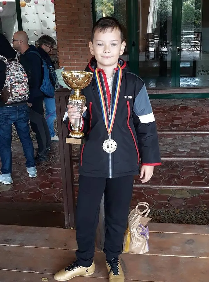 Copil cu cupă la concurs de șah